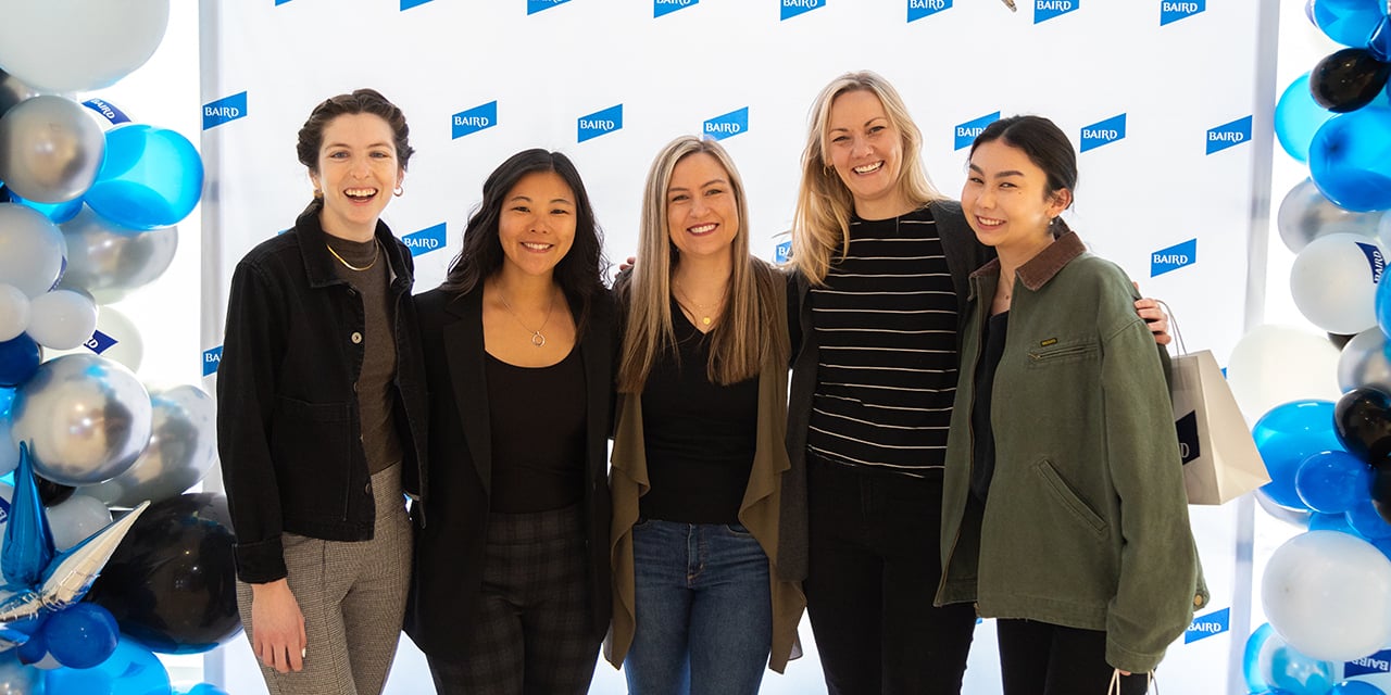Five women stand before a RJF Pro backdrop with blue, white, and silver balloons.