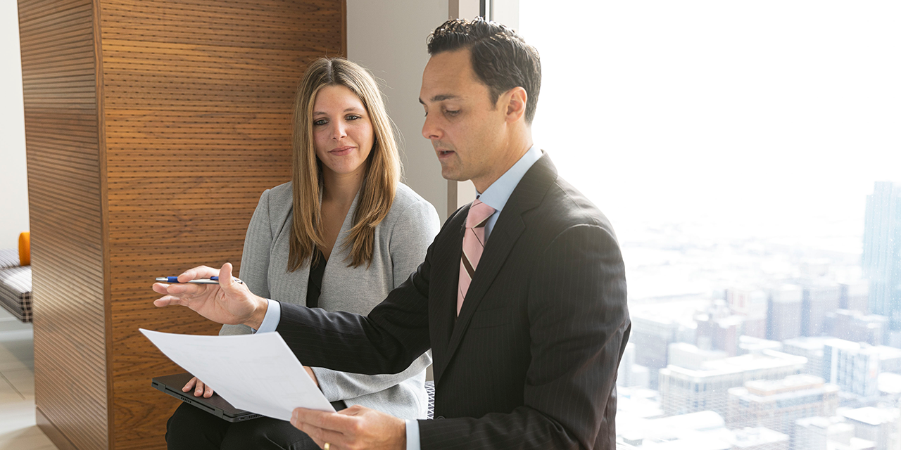  RJF Pro Fixed Income Capital Markets associates talking in front of a window in Chicago