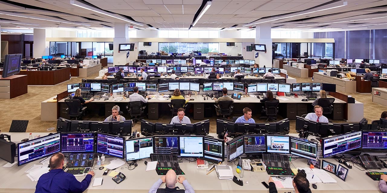  RJF Pro trading floor wide angle shot of traders at desks looking at computers.
